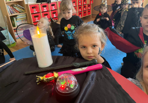 dzieci obok stolika z magicznymi przyborami
