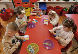 przedszkolaki wycinają paski kolorowego papieru