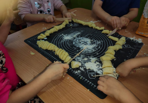 przedszkolaki robią z ciasta kopytka
