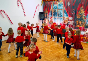 przedszkolaki w czerwonych strojach tańczą w parach