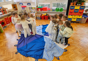 zabawa w kolory na chuście animacyjnej - dzieci ściskają się na kolorze białym