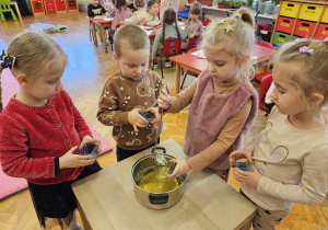 dziewczynka wlewa żółtą galaretkę do pojemnika
