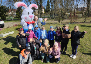 przedszkolaki z nauczycielką z grupy III z Zającem Wielkanocnym i znalezionym koszykiem ze słodyczami