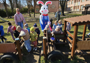 dzieci znajdują koszyk w wagonikudrewnianego pociągu w ogrodzie