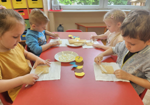 dzieci smarują miodem wafelki
