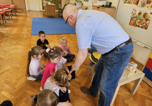dzieci oglądają kratkę z woskiem wykonanym przez pszczoły
