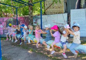 przedszkolaki bujają się na kolorowej kłodzie