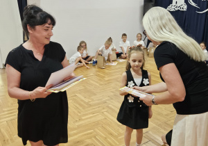 pani dyrektor Justyna Kunert wręcza dziewczynce dyplom w asyście nauczycielki