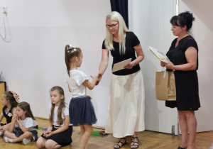 pani dyrektor Justyna Kunert wręcza dziewczynce dyplom w asyście nauczycielki