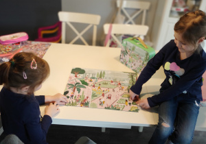 dziewczynki układają puzzle na stole