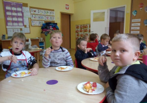 dzieci jedzą sałatkę przy stolikach