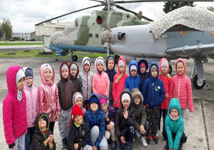 dzieci pozują do zdjęcia przed helikopterem