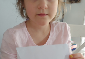 dziewczynka pokazuje złożoną kopertę