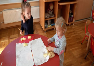 dziewczynki kroją jabłka na drewnianych deskach