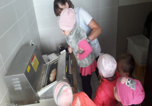 maszyna kroi chleb i pokazuje dzieciom - podnosi dziewczynkę