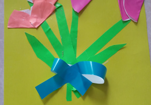 laurka na żółtym tle - origamii - cztery różowe tulipany z zielonymi łodyżkami i liściami "przewiązane" niebieską wstążką