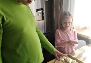 chłopiec i dziewczynka robią kluseczki w kształcie kulek z masy solnej