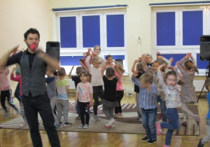 dzieci tańczą z prowadzącym obracając się wokół siebie
