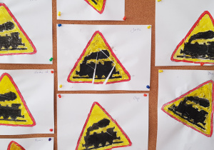 praca plastyczna; znak drogowy ostrzegawczy przejazd kolejowy bez zapór - puzzle - znak pomalowany kredkami, pocięty na kawałki i naklejony na kartkę