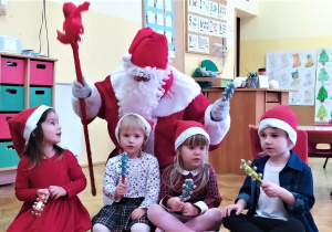 dzieci grają na instrumentach a dziewczynka rozmawia z Mikołajem