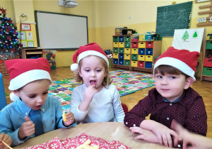dzieci przy stoliku jedzą chrupki