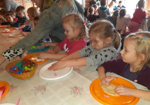 dzieci wyciskają ciastka z foremek