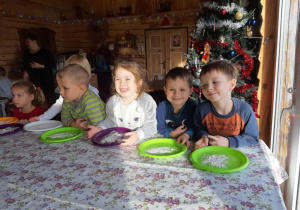 dzieci mają mąkę na zielonych talerzach, położonych na stole