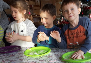 dzieci ugniatają ciasto w dłoniach
