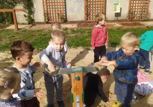 dzieci bawią się w piaskownicy wagą