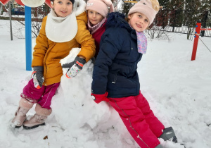dziewczynki siedzą na kuli śniegowej