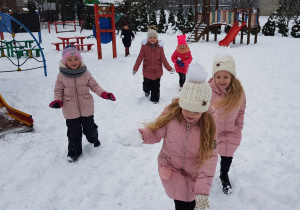 dziewczynki ganiają się i rzucają się śniegiem