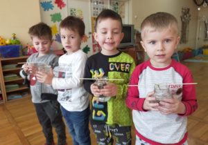 4 chłopców trzyma słoiki z hodowlą kryształków soli