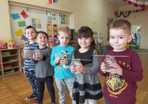 pięcioro dzieci trzyma słoiki z hodowlą kryształków soli