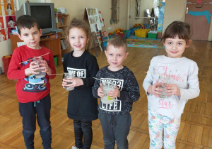 czworo dzieci trzyma słoiki z hodowlą kryształków soli