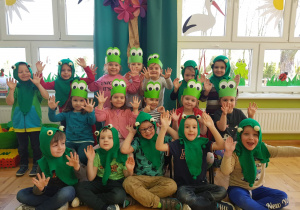 dzieci z grupy I pozują do zdjęcia przebrane za zielone żabki