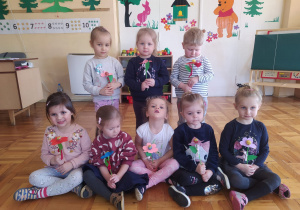 dziewczynki z grupy II trzymają kwiatki wykonane na lizakach o kształcie kulki