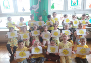 dzieci z grupy IV pokazują prace plastyczne z pokolorowanym słoneczkiem