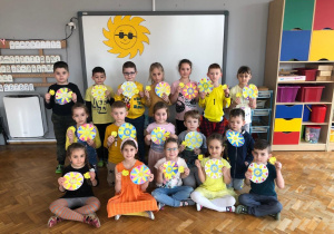 dzieci z grupy VII pozują do zdjęcia z medalami w kształcie słoneczka oraz pomalowanymi mandalami ze słoneczkiem