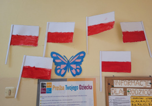 flagi polskie wykonane przez dzieci wiszą na ścianie przed salą