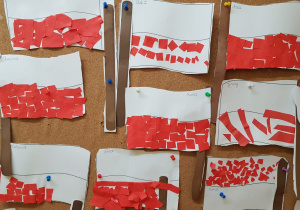 flagi polskie wykonane przez naklejanie czerwonych, pociętych kawałków papieru