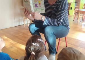 nauczycielka czyta dzieciom bajkę o Bolku i Lolku