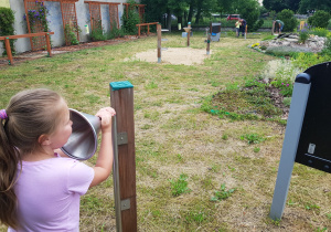 córka składa życzenia tacie przez instalację telefoniczną w ogrodzie przedszkolnym