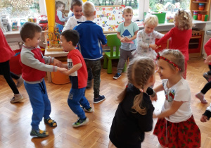 dzieci tańczą w parach - trzymają się za ręce i podskakują