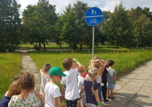 dzieci stoją przy znaku informacyjnym - ścieżka dla rowerów i pieszych