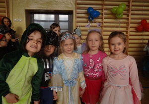 5 dzieci pozuje do zdjęcia: smok, rycerz, motylek i 2 księżniczki