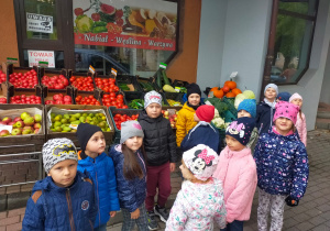 dzieci na wycieczce przed sklepem warzywnym
