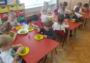 dzieci wykonują jeżyki z gruszek i winogrona oraz wykałaczek