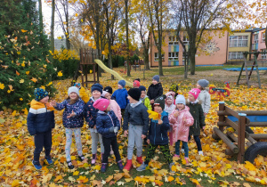 na dzieci w ogrodzie przedszkolnym lecą kolorowe liście