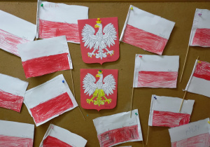 prace plastyczne - godło i flagi Polski wykonane przez dzieci, kolorowane kredkami