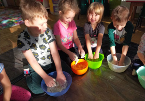 dzieci ugniatają ciasto w kolorowych miskach